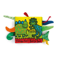 Load image into Gallery viewer, Wrinkly, crinkly, crunchety crunch. The dino pals are out to play. Discover the different textures, shapes and sizes of all their tails. This vibrant and colourful book will captivate the eyes of any baby, toddler or child. Made for little hands, the fabric is uber soft, with built in CRUNCH!
