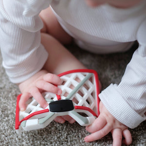 Hey Hockey Fans! THE HOCKEY NET silicone teether is perfect for hands to grab and chew on. The back has sensory bumps for little fingers and the geometric design attaches easily to pacifier clip